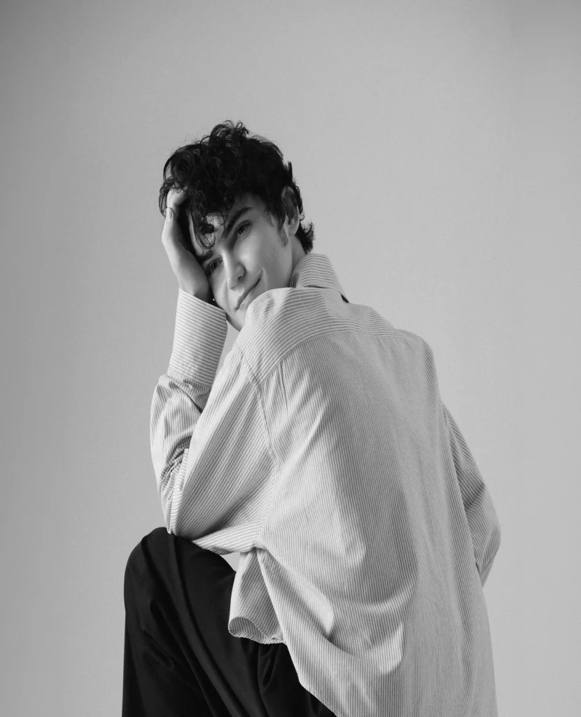 Gleb in a white shirt resting his head on his hand